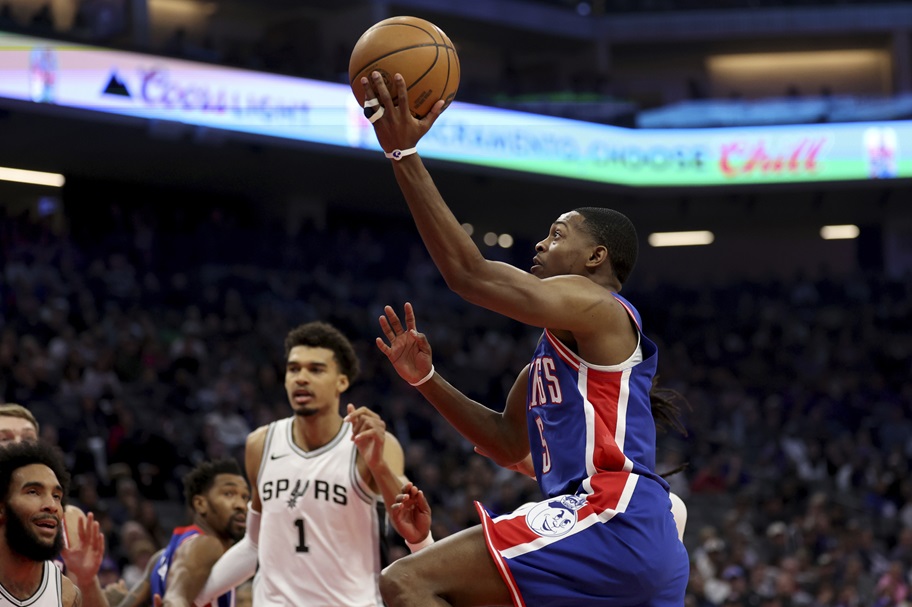 De'Aaron Fox makes a layup with Victor Wembanyama looking on.